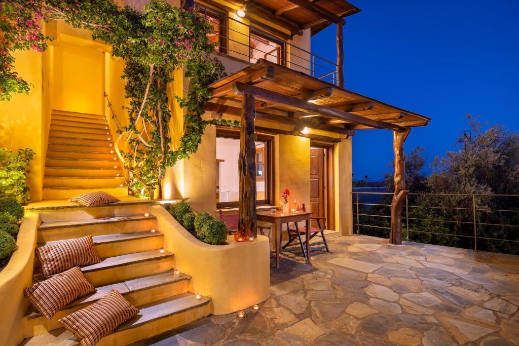 a patio with stairs leading up to a house at Alkifron Hotel in Kala Nera