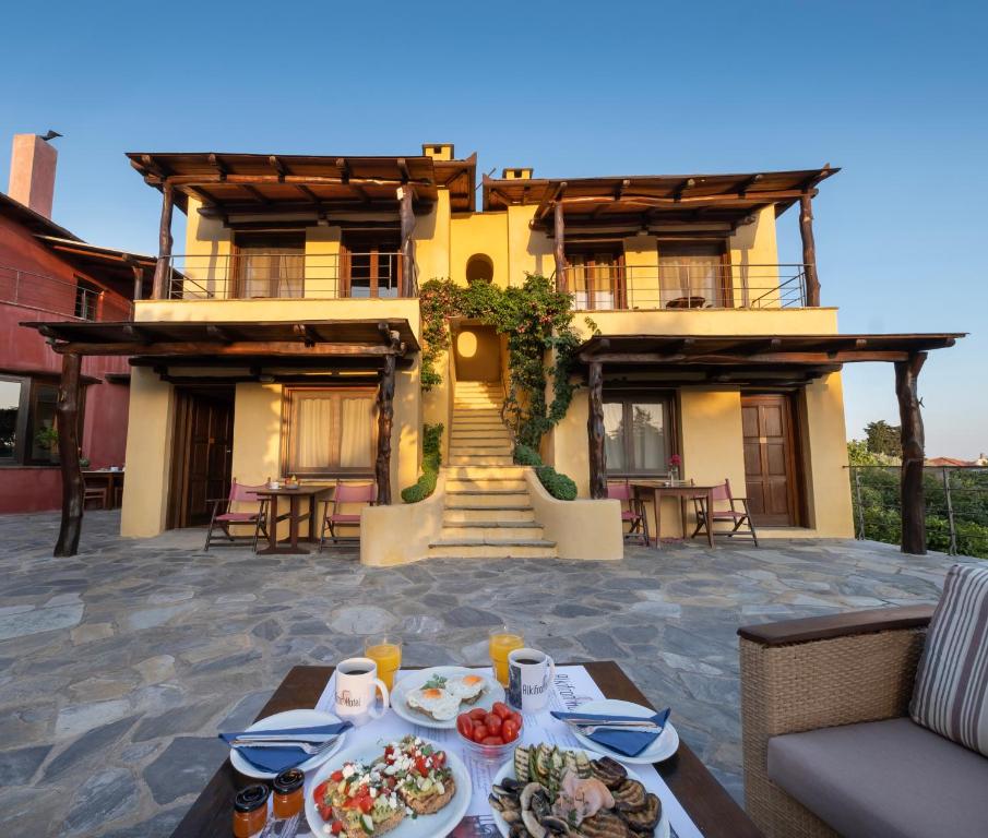 a house with a table of food in front of it at Alkifron Hotel in Kala Nera