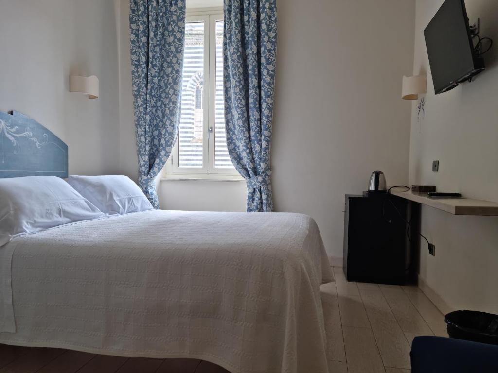 A bed or beds in a room at Hotel Virgilio
