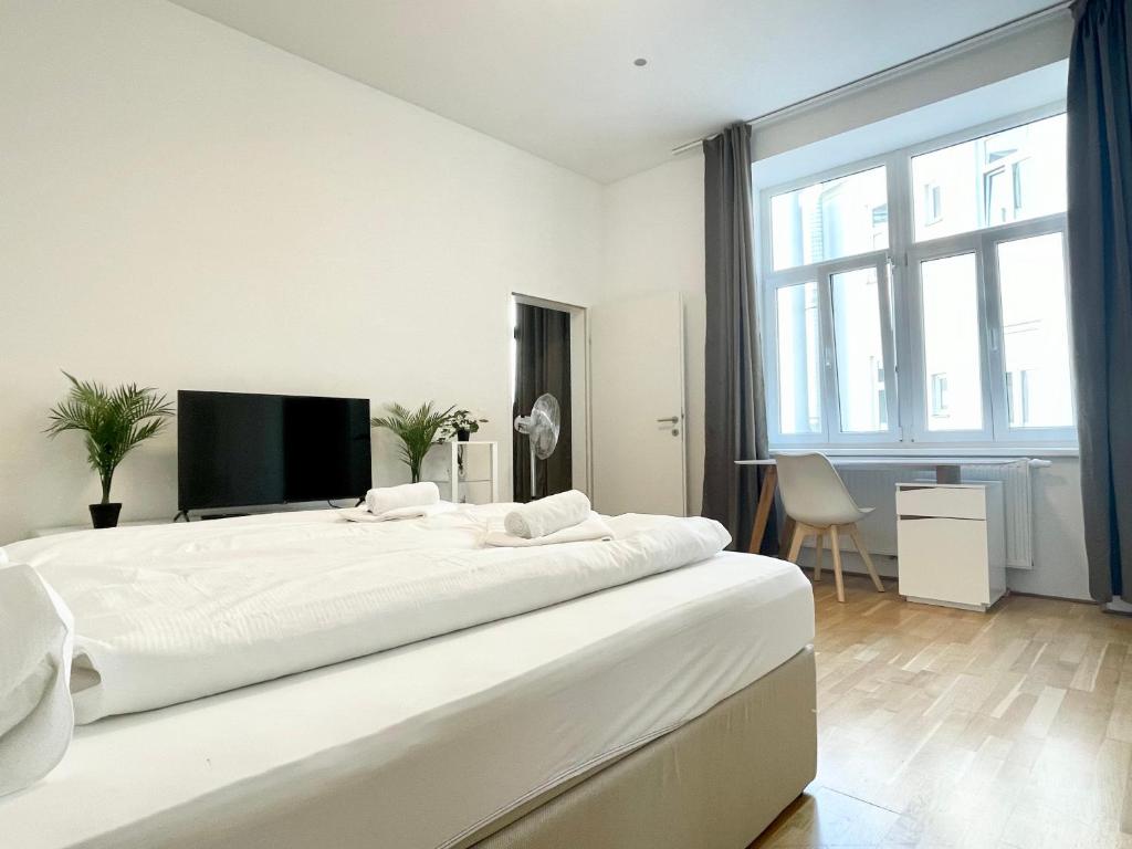 um quarto branco com uma cama grande e uma janela grande em Cosy Residence at famous Vienna Kutschkermarkt em Viena