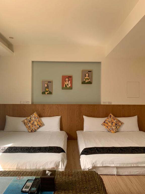 twee bedden in een hotelkamer met twee bij 開心居-正市中心電梯民宿-步行東大夜市5分鐘 in Hualien