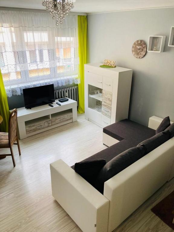 a living room with a couch and a tv at Apartamenty Every Sky Plac Ratuszowy 30 in Jelenia Góra