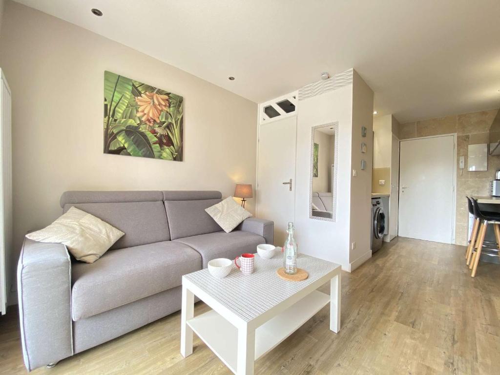 un salon avec un canapé et une table dans l'établissement Studio moderne avec balcon sud, parking privé, près avenue De Gaulle - 2 couchages à La Baule - FR-1-245-107, à La Baule