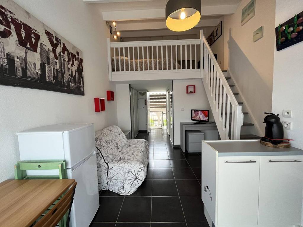 Il comprend une cuisine et un salon avec un réfrigérateur et des escaliers. dans l'établissement Appartement Saint-Cyprien, 1 pièce, 4 personnes - FR-1-106-85, à Saint-Cyprien