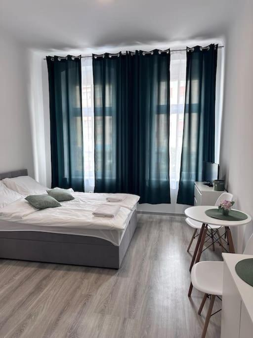 ein Schlafzimmer mit einem großen Bett und einem Tisch in der Unterkunft Przytulny apartament in Szczecinek