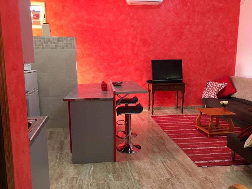 - un salon avec un mur rouge et une table dans l'établissement Apatomentos Fortuna Leisure, à Fortuna