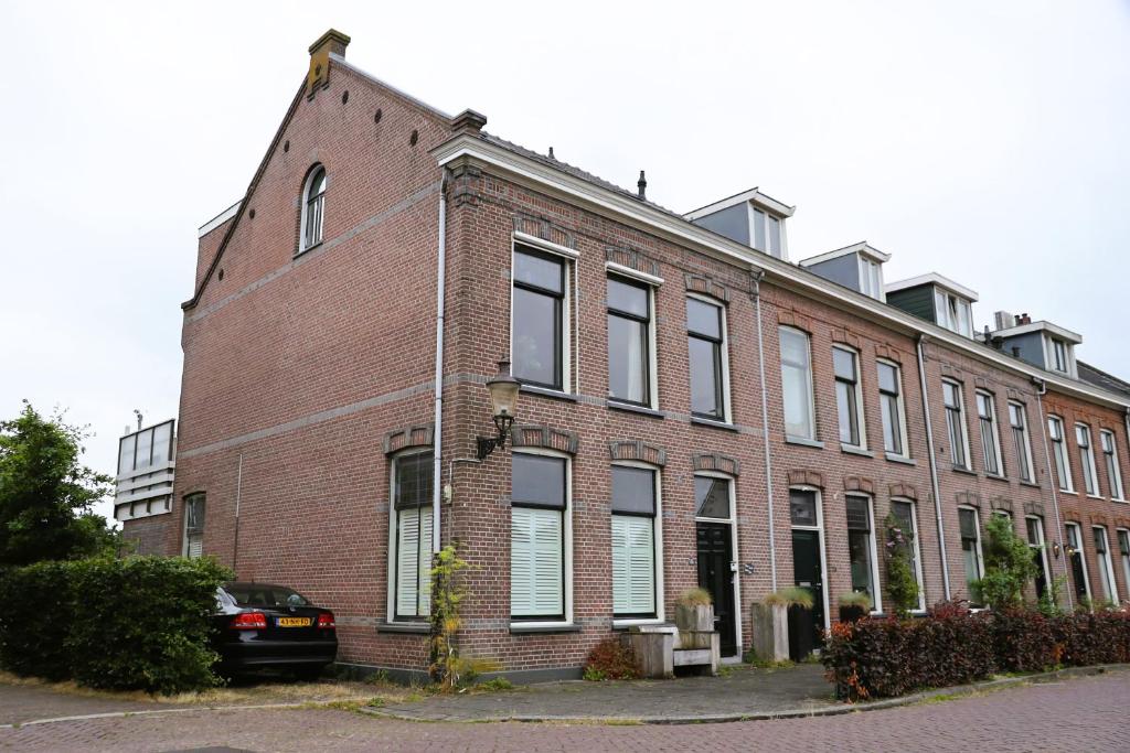 a brick building with a car parked in front of it at B&B Vechtzicht in Weesp