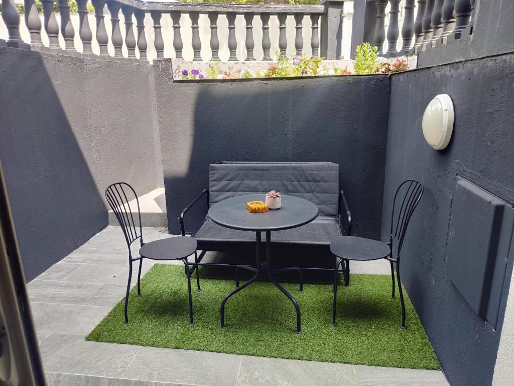 a table with two chairs and a bowl of fruit on it at Appartement terasse in Saint-Maur-des-Fossés