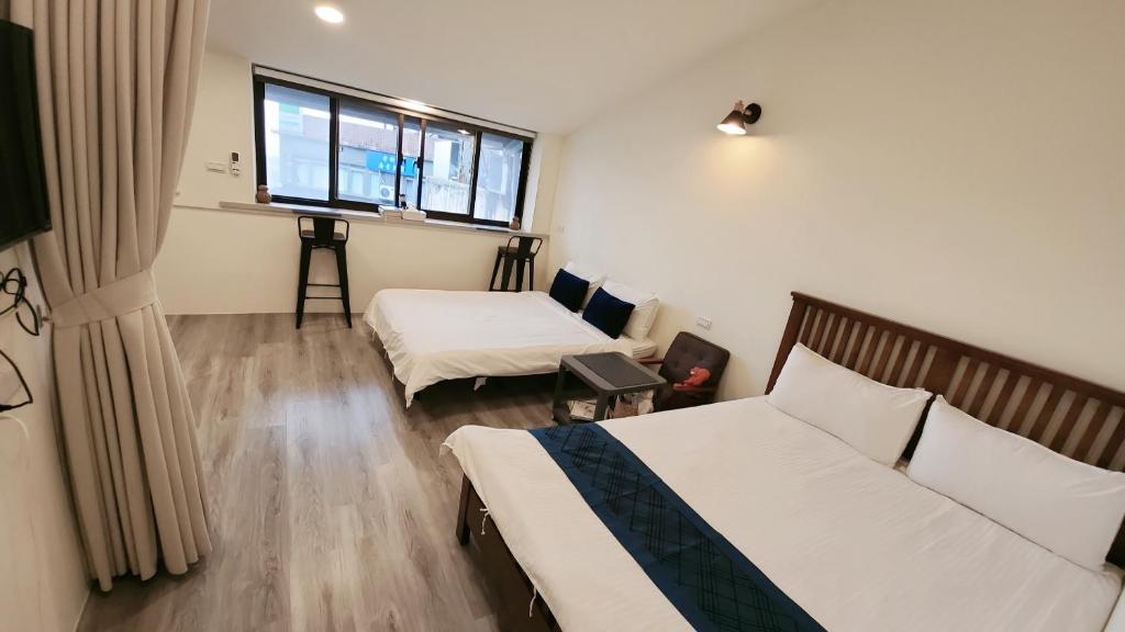 ein Hotelzimmer mit 2 Betten und einem Fenster in der Unterkunft Stay if you wish Homestay in Jiufen