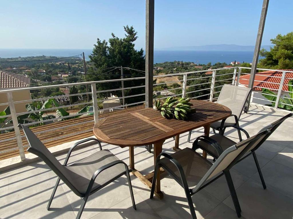 a wooden table and chairs on a balcony at blue view sea apartment in Ratzaklíon