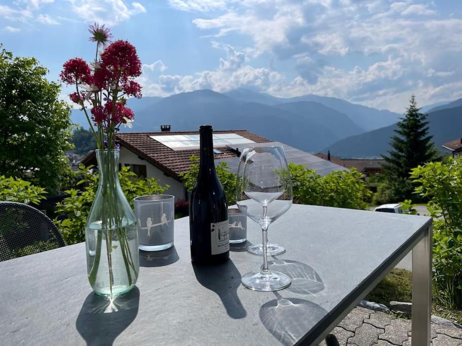 einen Tisch mit zwei Weinflaschen und Gläsern darauf in der Unterkunft Wohnung mit fantastischer Aussicht in Trin