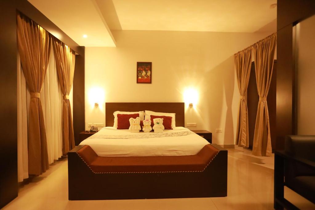 a bedroom with a bed with two stuffed animals on it at Hotel Finch in Erāttupetta