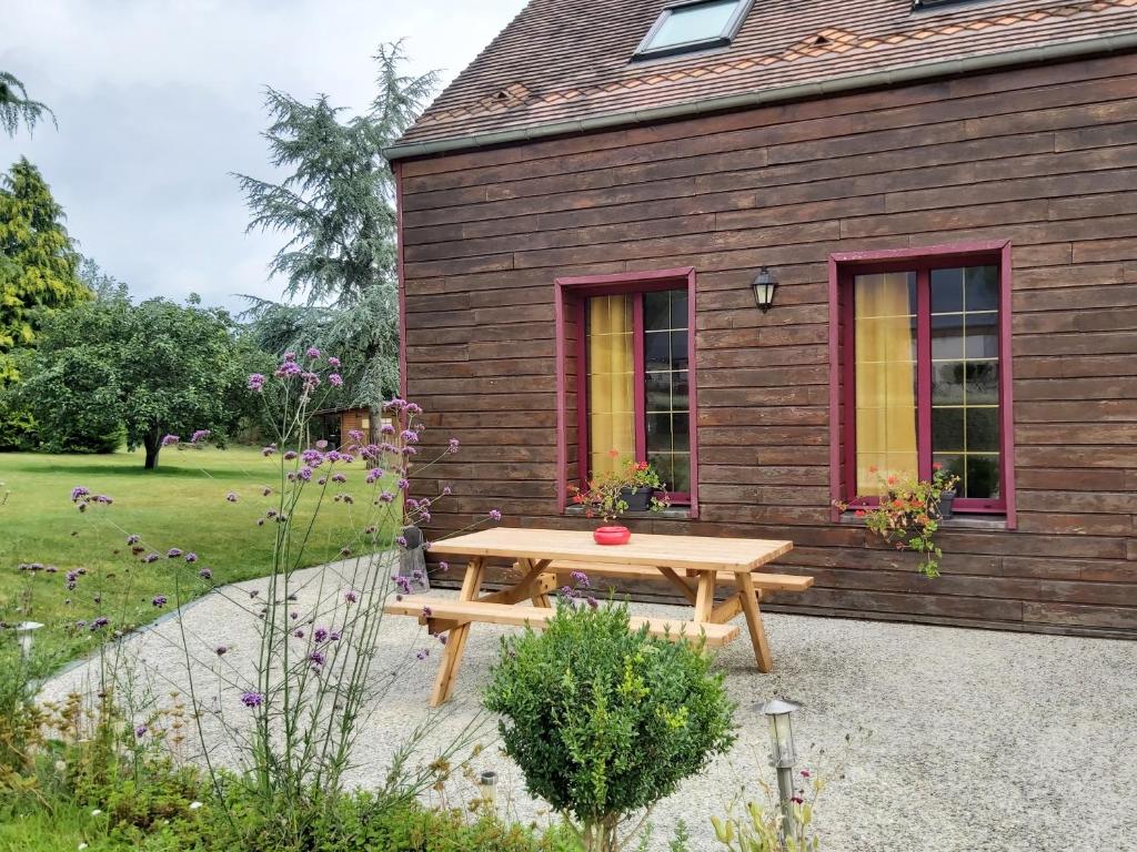 una mesa de picnic frente a una casa de madera en La Valette en Ménil-Hubert-sur-Orne