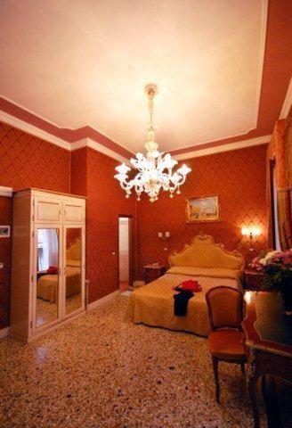 a bedroom with a bed and a chandelier at Residenza Hotel San Maurizio in Venice