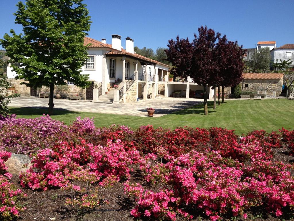 um jardim com flores cor-de-rosa em frente a uma casa em Casa do Rocio 