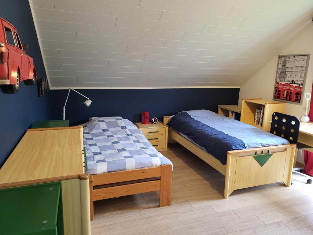 1 dormitorio con cama, escritorio y cama sidx sidx sidx sidx en Chambre London proche du circuit, en Spa