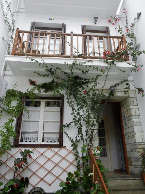 ein weißes Gebäude mit Fenstern und einem Balkon in der Unterkunft Aggela Guesthouse in Skopelos