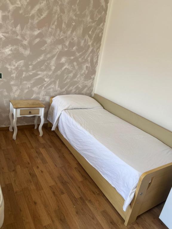 um pequeno quarto com uma cama e uma mesa em B&B Treviso em Treviso