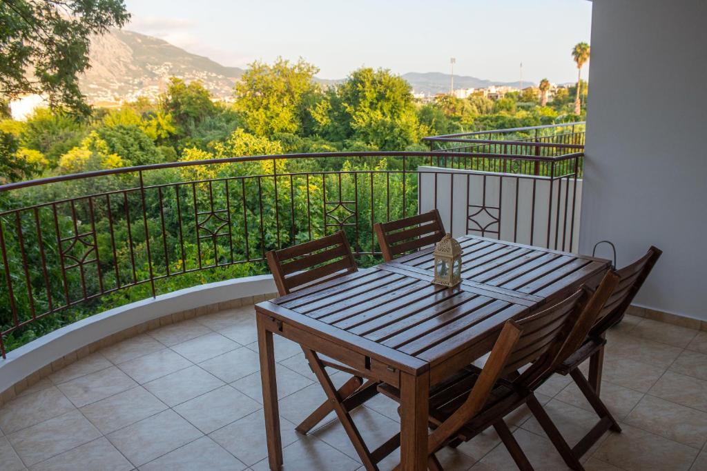 a wooden table and chairs on a balcony at Odysseas Home Kalamata in Kalamata