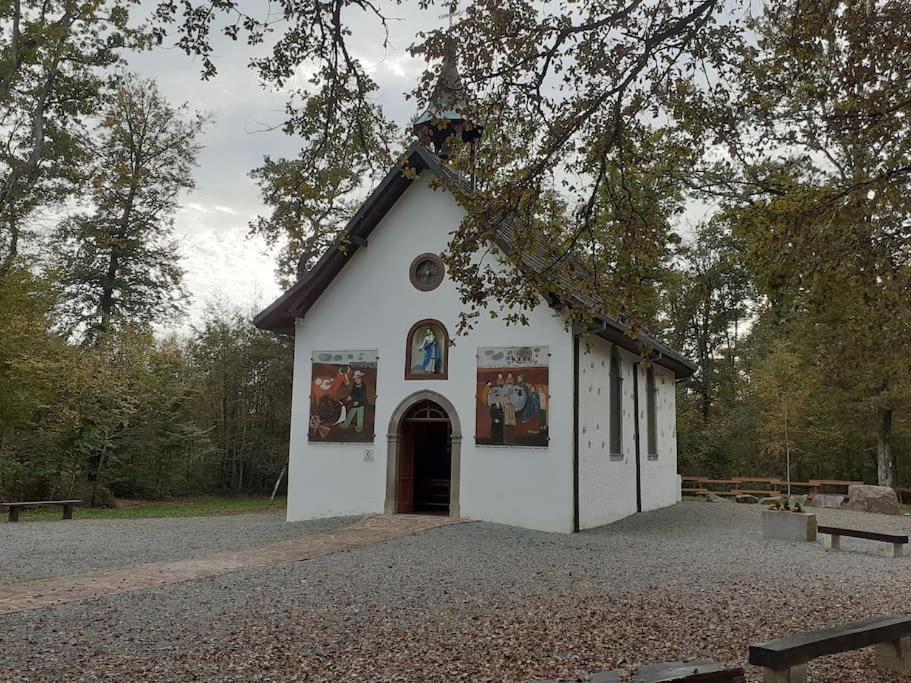 ein kleines weißes Gebäude mit einem großen Eingang in der Unterkunft A l'Orée du Bois ''Les Hêtres'' in Guewenheim