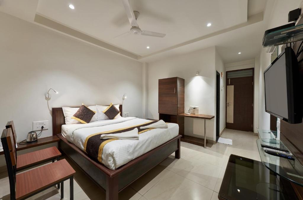 Schlafzimmer mit einem Bett und einem Flachbild-TV in der Unterkunft Hotel Fortune Inn in Kolhapur