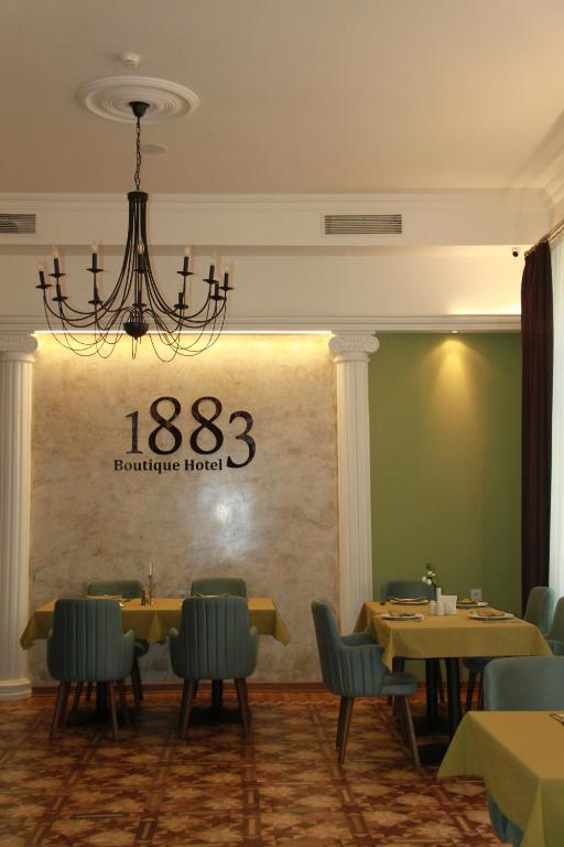a dining room with tables and chairs and a chandelier at Hotel 1883 in Baku