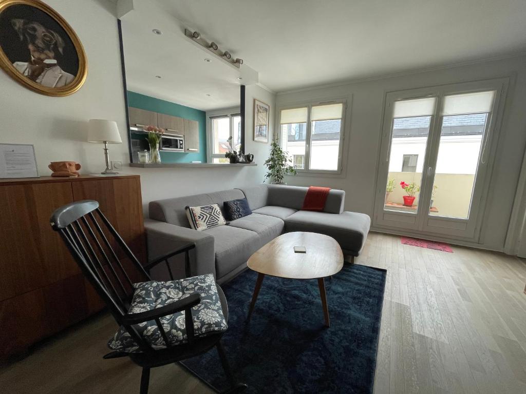 a living room with a couch and a table and chairs at Spacious 1 bedroom apartment near Paris in Garches