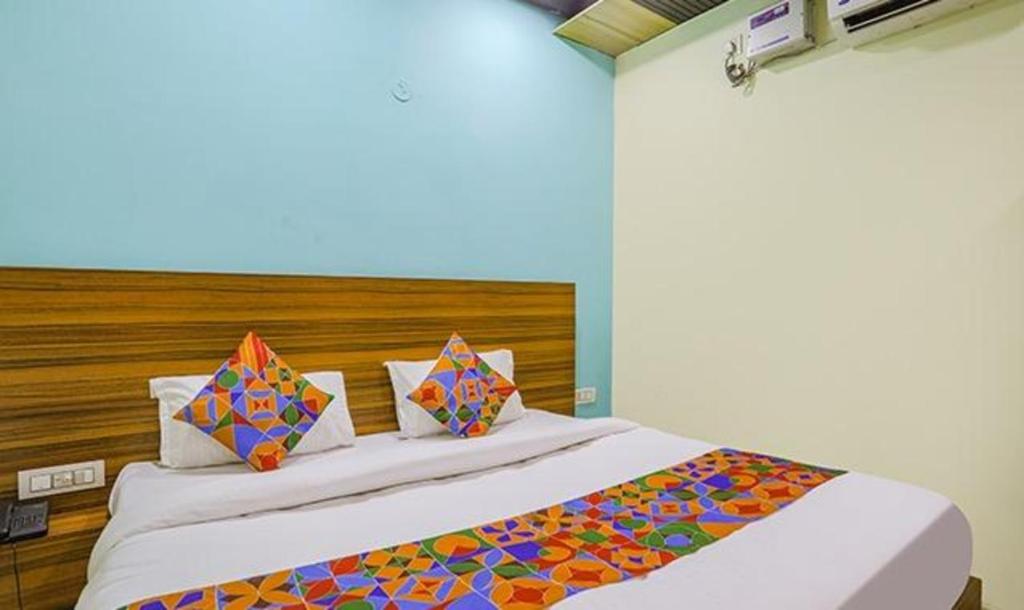 una camera con un grande letto con testiera in legno di FabHotel Yatika Inn a Bhairaun Ghāt