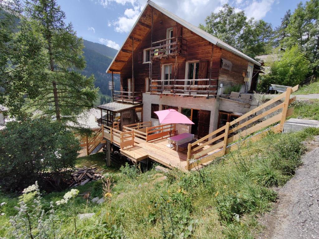 a wooden house with a porch and a balcony at Chalet Ailleurs Appartement à Molines en Queyras in Molines-en-Queyras