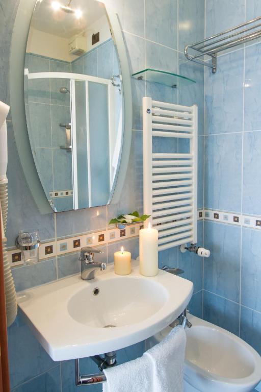 łazienka z umywalką i lustrem w obiekcie Hotel Nord Est w Rimini
