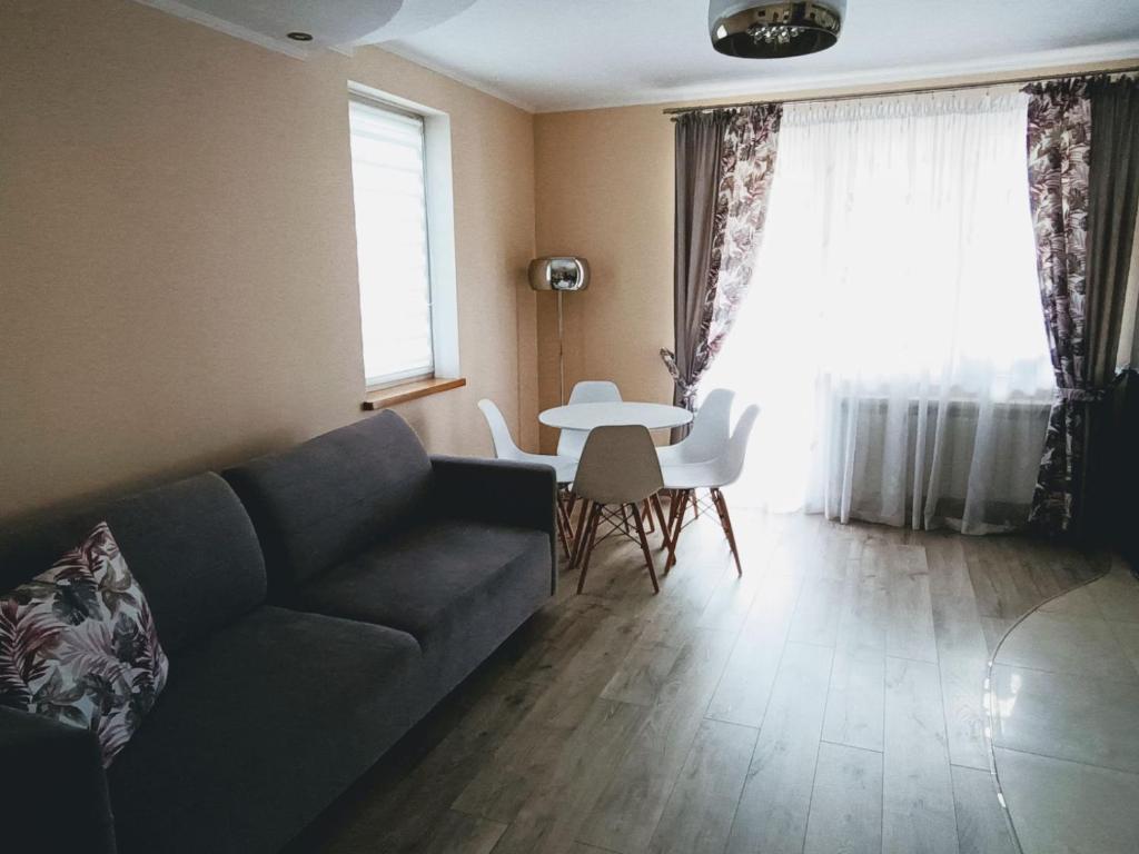 a living room with a couch and a table at Apartament comfort in Pisz