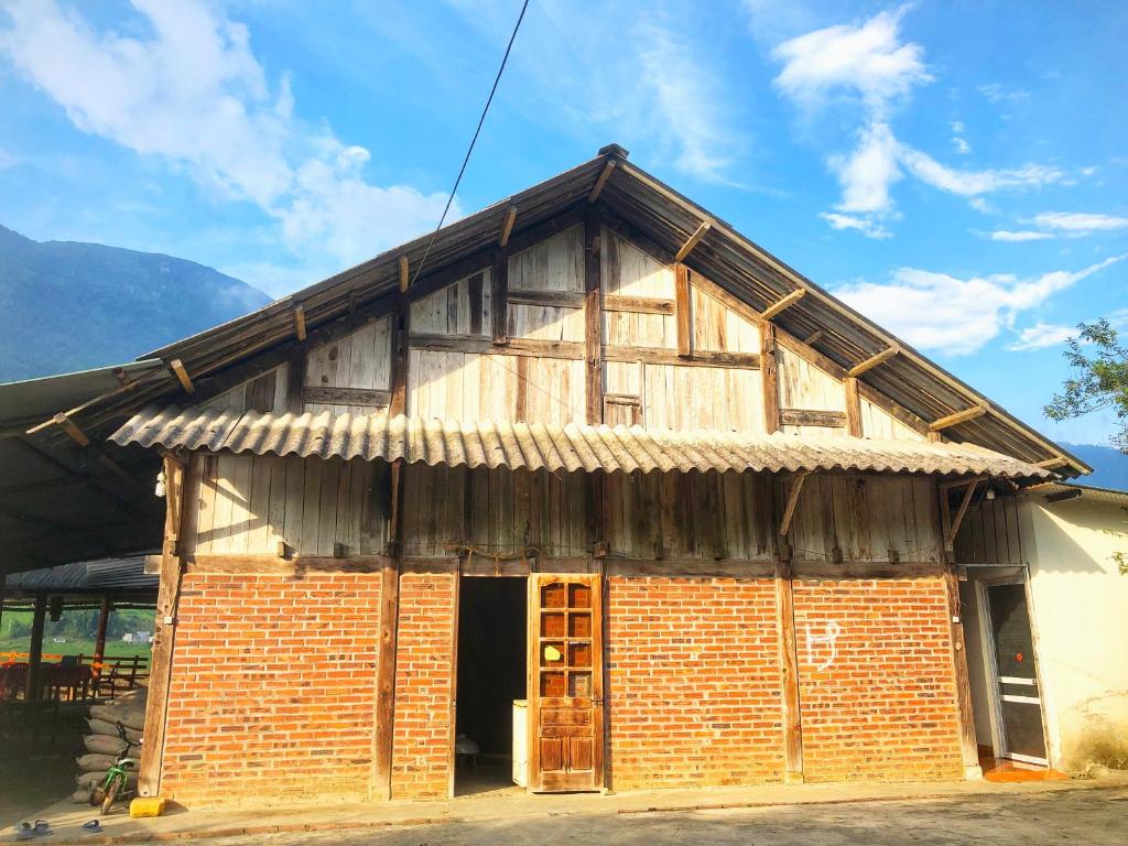 um antigo edifício de tijolos com telhado de madeira em Thanh Xuan Homestay and Bungalow em Sa Pả