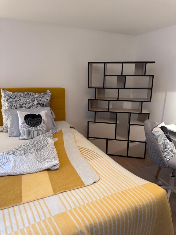 1 cama con manta amarilla y blanca y silla en Appartement im Geteviertel, en Bremen