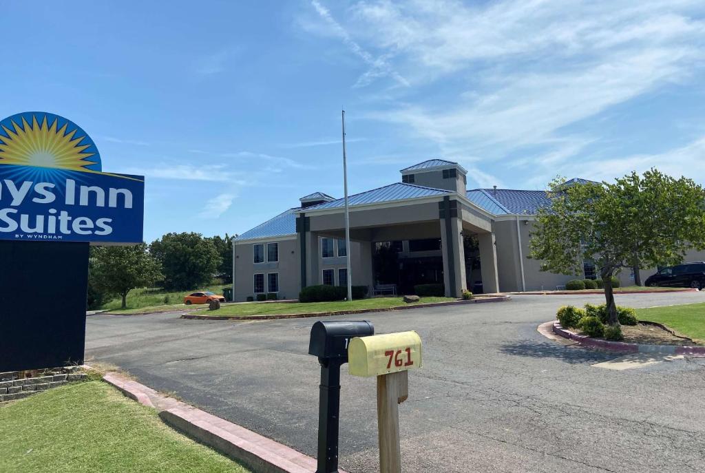un edificio con un parquímetro delante de él en Days Inn &amp; Suites by Wyndham Tahlequah, en Tahlequah