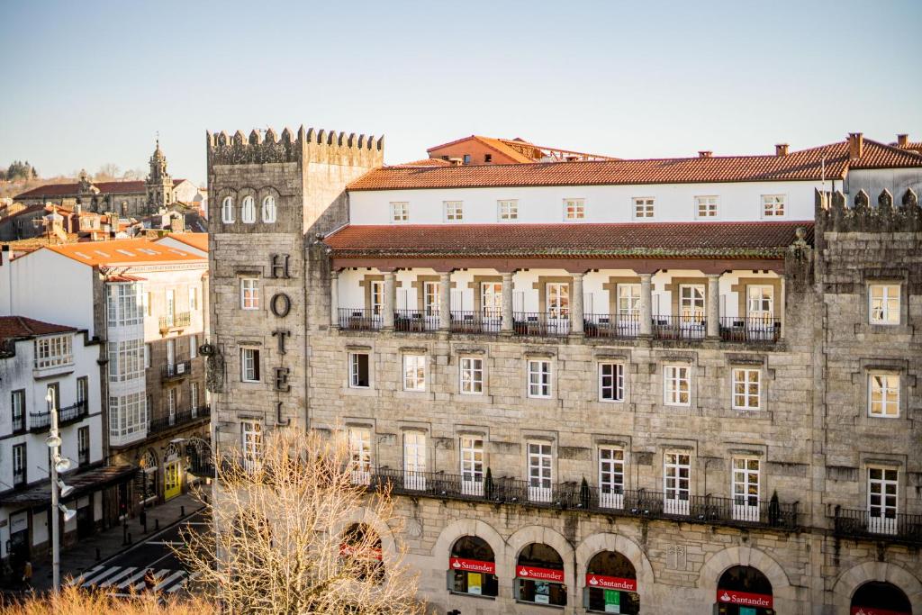 un vieux bâtiment avec une tour d'horloge dans une ville dans l'établissement Hotel Compostela, à Saint-Jacques-de-Compostelle