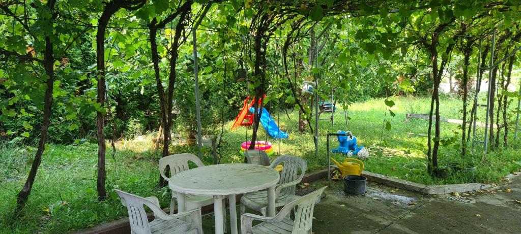 a table and chairs in a yard with trees at GM Place apartment 60 m2 in Gornji Milanovac