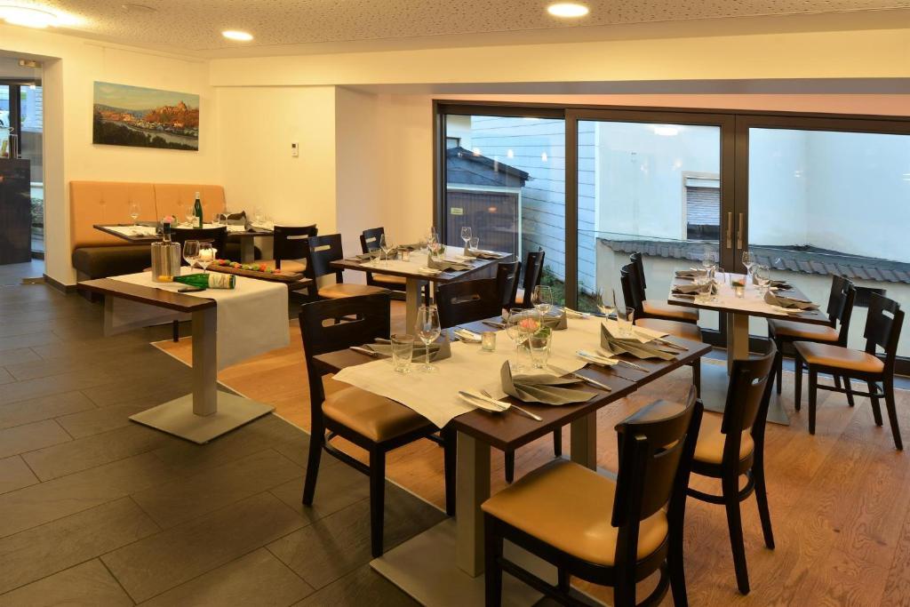 une salle à manger avec des tables et des chaises dans un restaurant dans l'établissement Linden's Pension-Restaurant, à Ayl