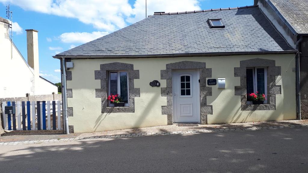 Casa pequeña con 2 ventanas y puerta blanca en Gite Albert, en Scrignac