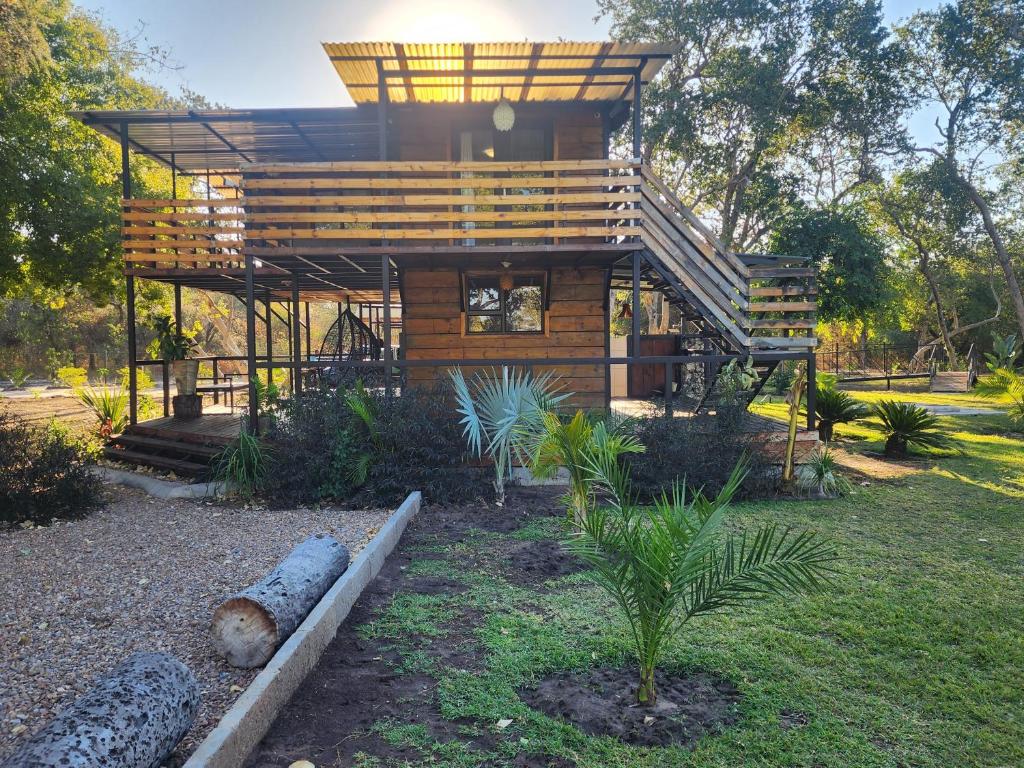 eine Holzhütte mit einer Treppe im Garten in der Unterkunft Lunar Garden Villa in Maun