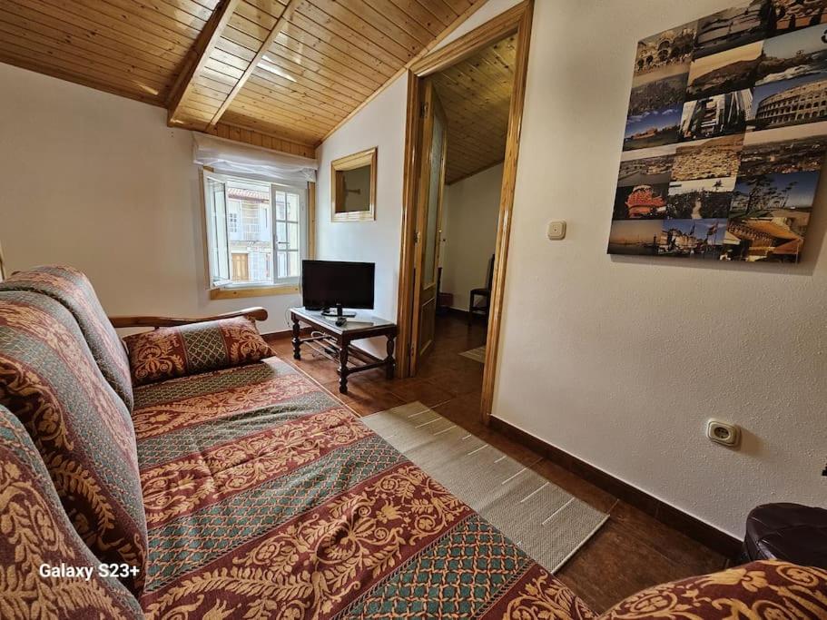 Una sala de estar con un sofá y un televisor. en Casa Lina VUT OR 000784, en Allariz