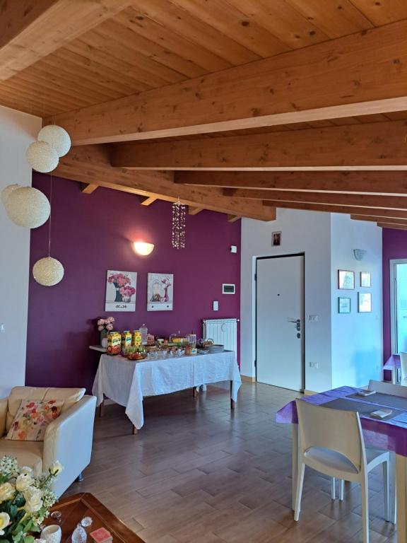 モンテジルヴァーノにあるB&B Carlottaの紫の壁のリビングルーム(テーブル付)