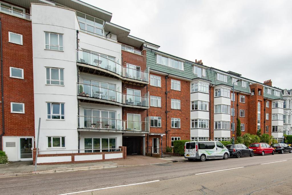 an apartment building with cars parked in front of it at Solent Court in Portsmouth