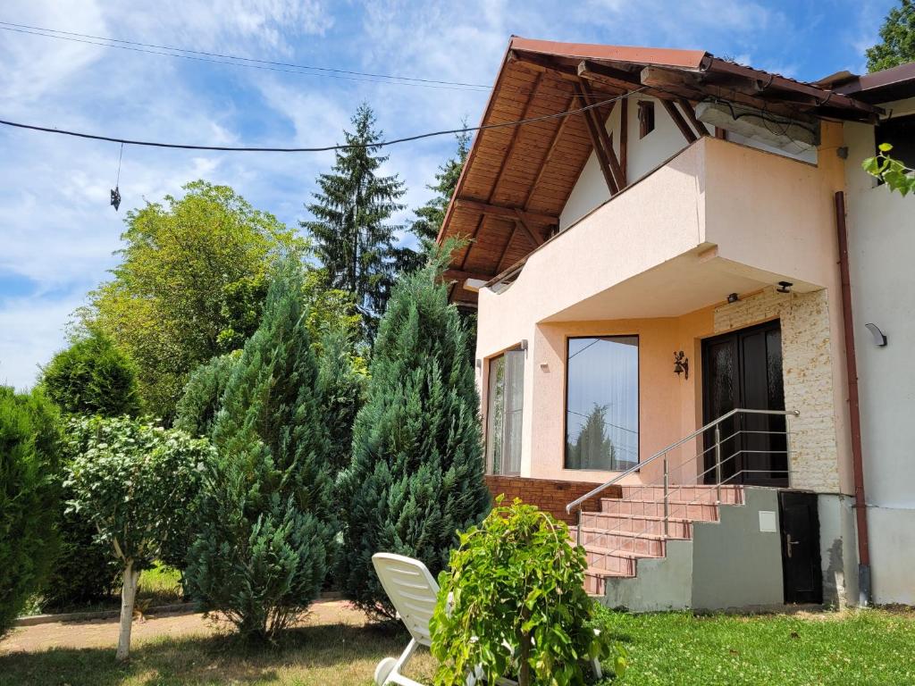 una casa con una silla blanca delante de ella en MaDaS en Bărbăteşti