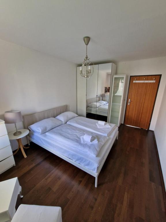 ein Schlafzimmer mit einem großen weißen Bett und einem Spiegel in der Unterkunft Vienna Schloss Schönbrunn 6 Appartment in Wien
