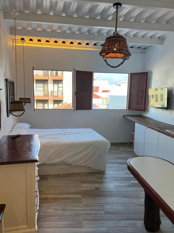 1 dormitorio con cama, escritorio y ventana en Casa Lourdes, en Santa Cruz de la Palma