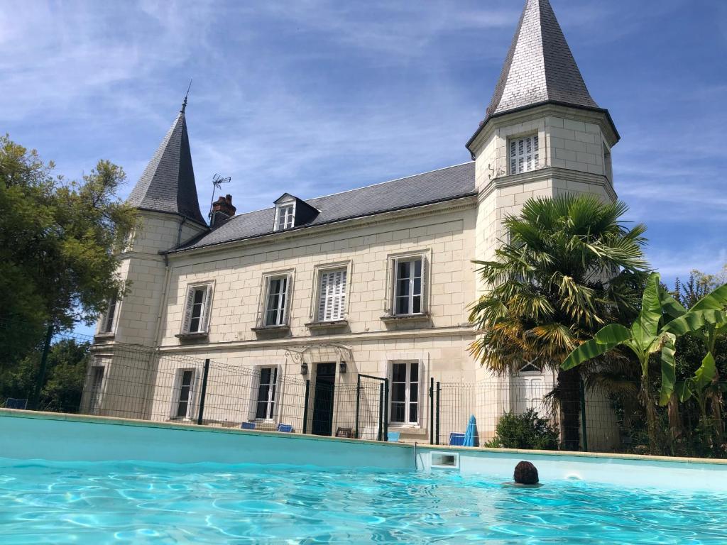 una persona in una piscina di fronte a un edificio di TourTour Guest Room a Saint-Avertin