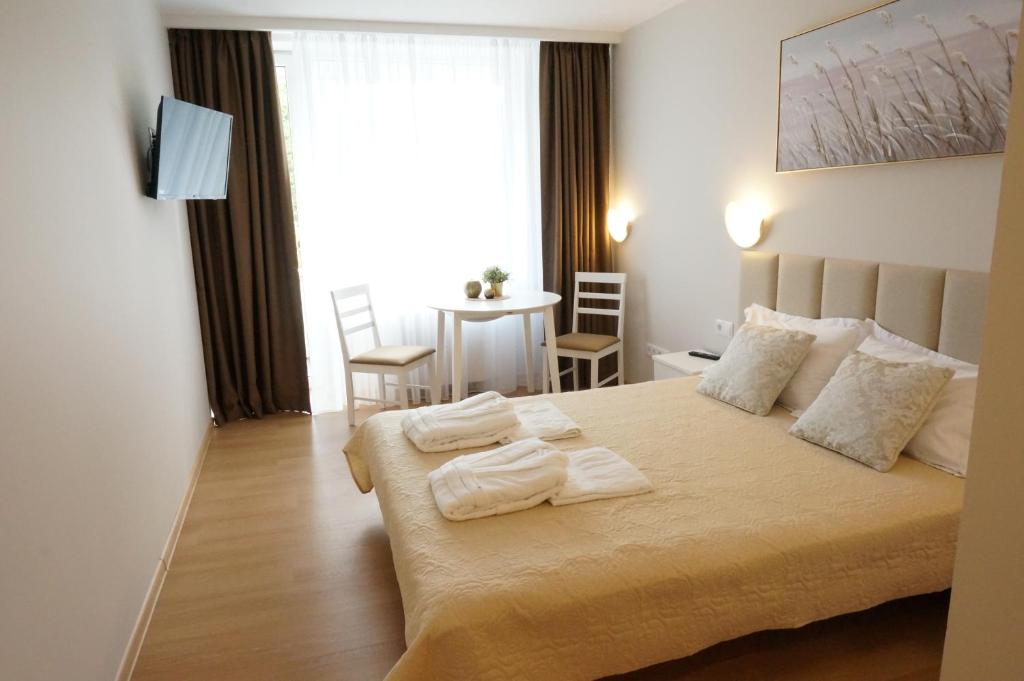 1 dormitorio con 1 cama con toallas en ALKA apartaments, en Palanga