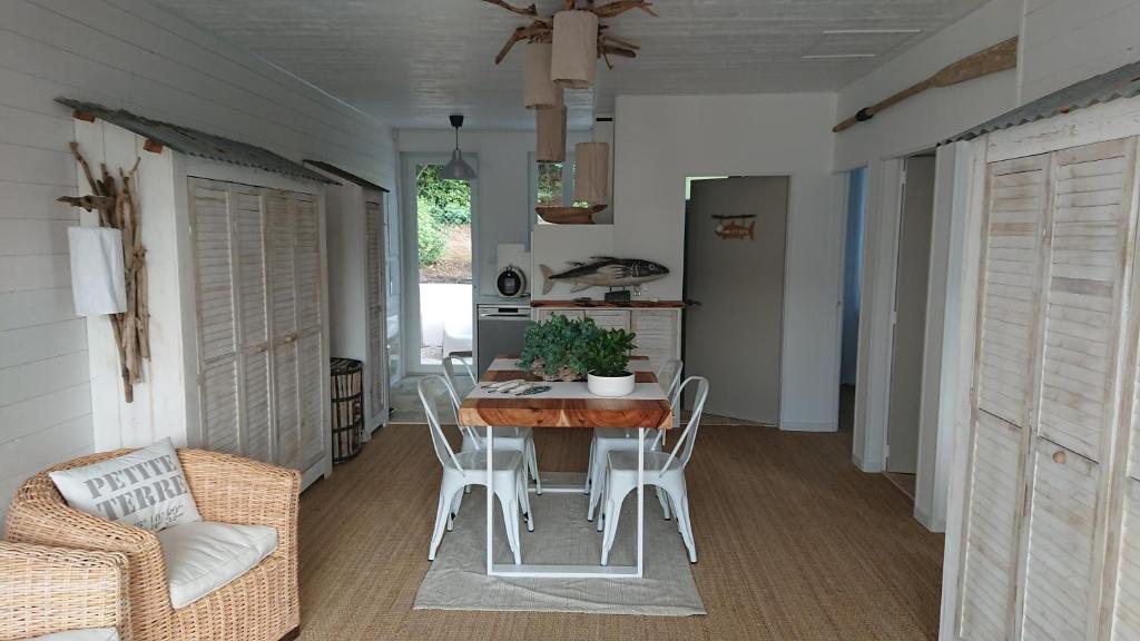 LOCATIONS NOS ILES في سان جان دي مونت: مطبخ وغرفة طعام مع طاولة وكراسي