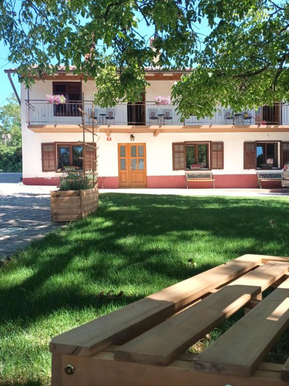 a building with a bench in front of a yard at Apartma Brina 3 in Sežana