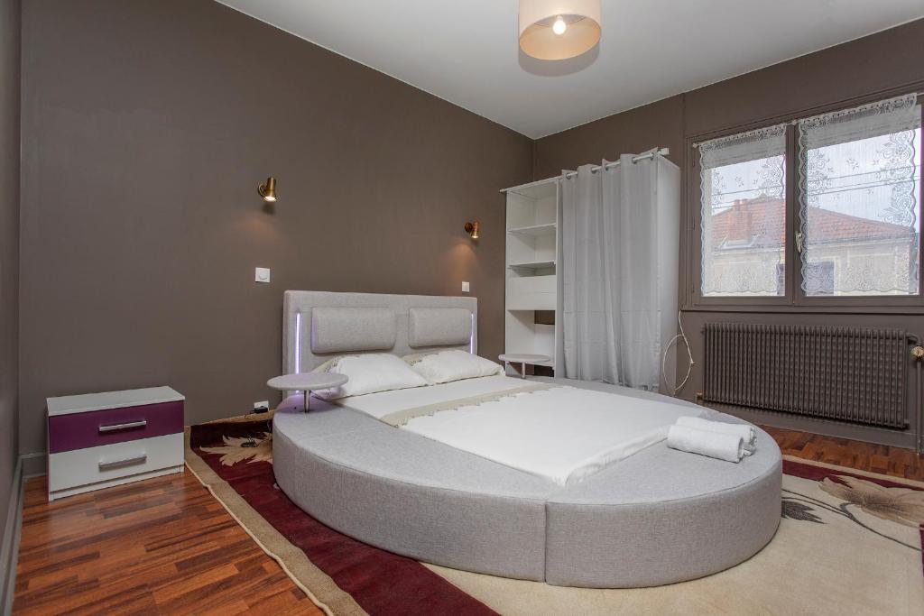 Un dormitorio con una cama grande y una ventana en BLUE HOME, en Roanne